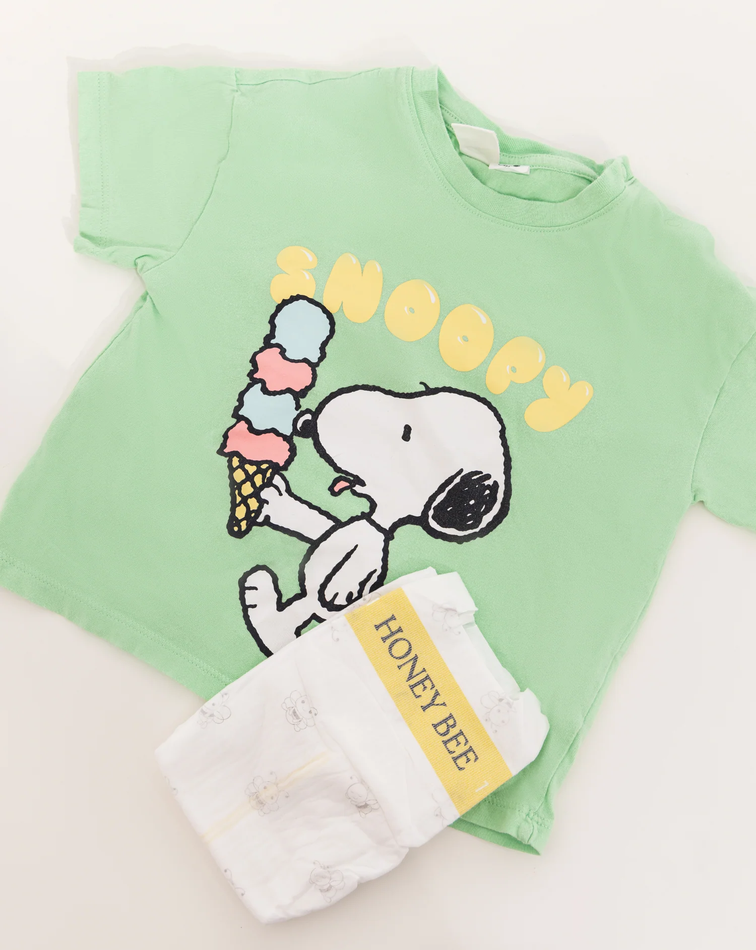 A Honey Bee diaper styled next to a child’s outfit